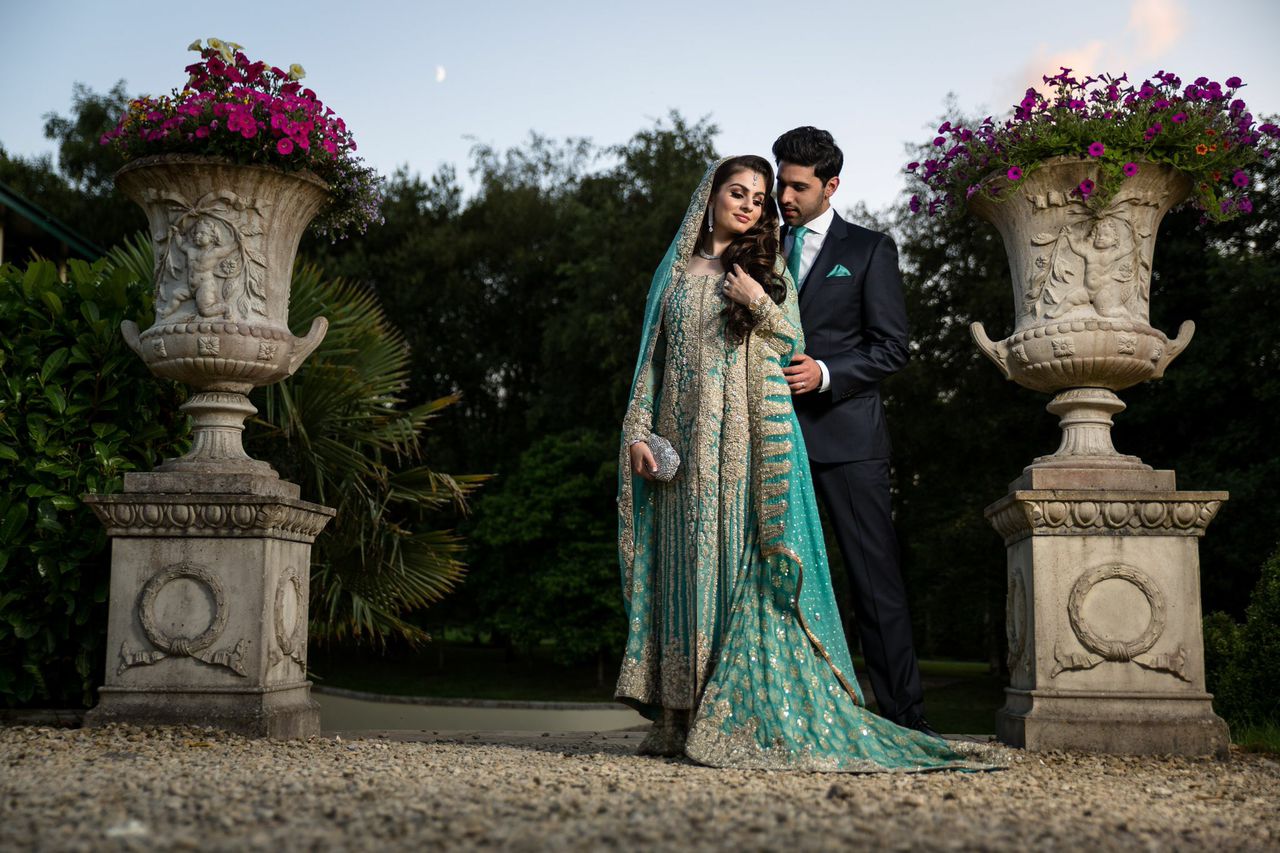 Asian Bride and Groom standing outside 