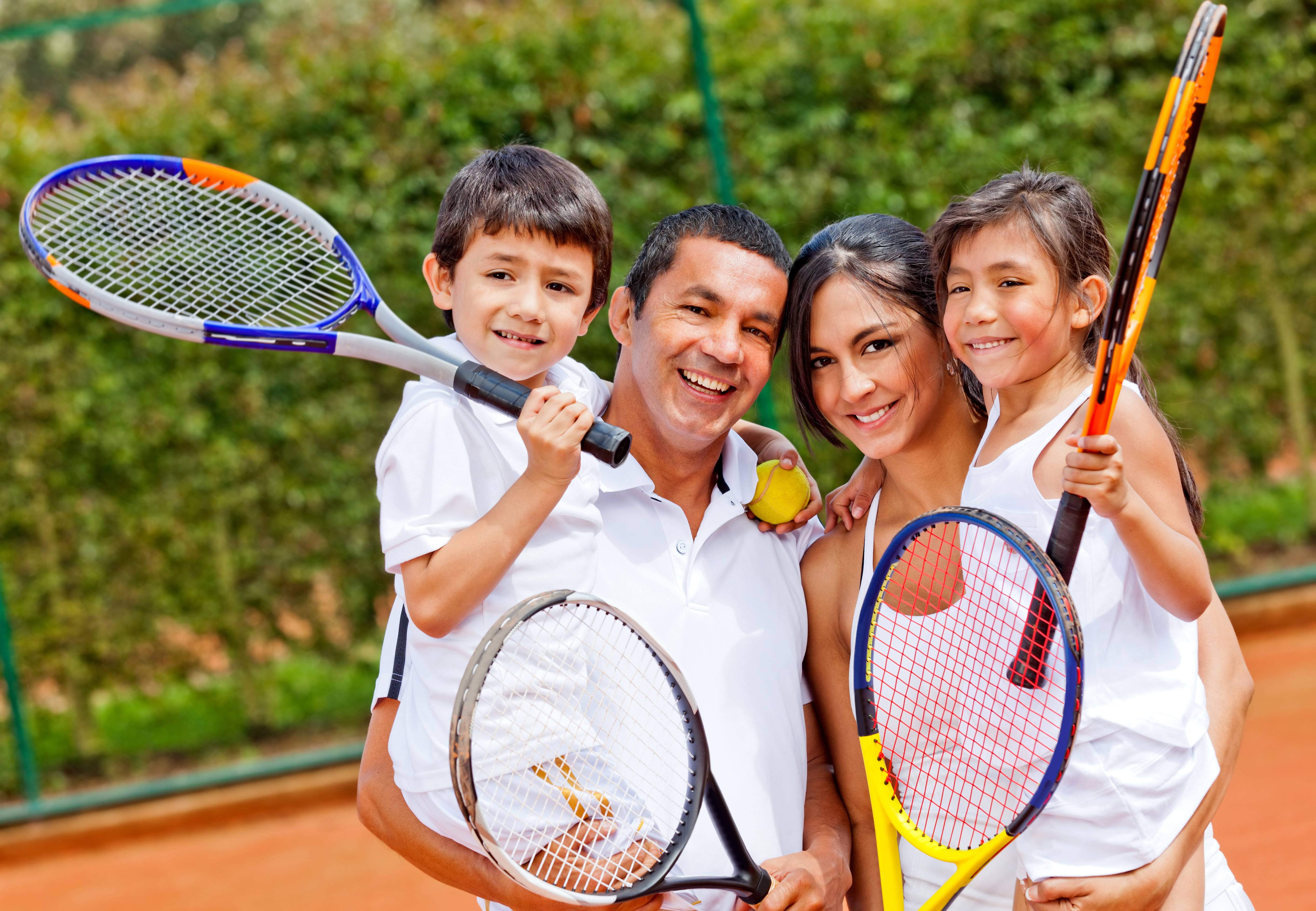 Family holding tennis rackets 